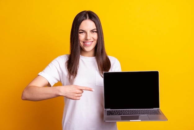 Photo of young girl promoter indicate finger laptop ads choose advise isolated over yellow color background