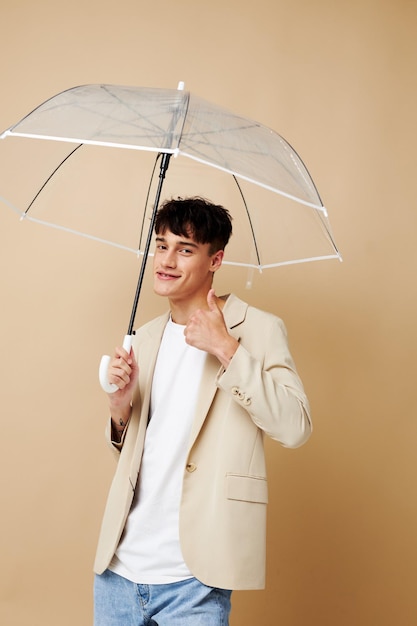 Photo of a young guy in a white jacket with an open umbrella