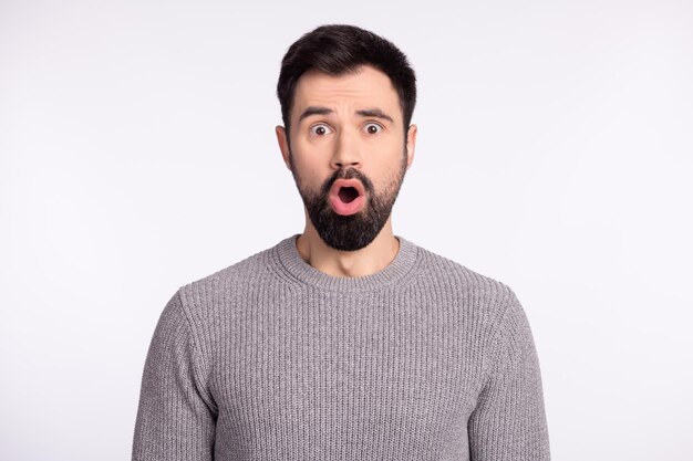 Photo of young handsome man amazed shock surprised fake novelty news isolated over grey color background