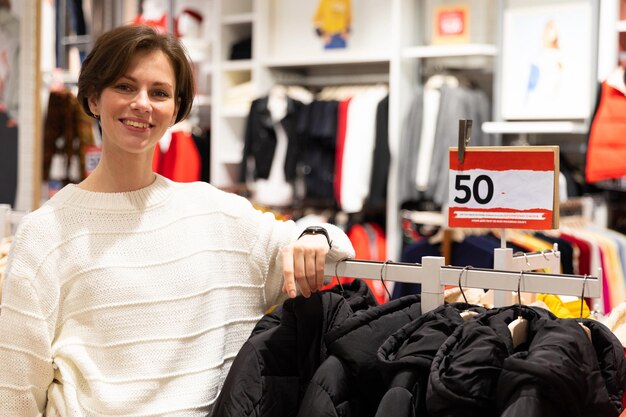 Photo of young happy positive and amiling attractive brunette woman with a short haircut in a white