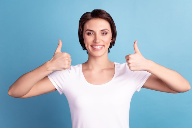 Photo of young lovely girl show thumbs-up advertise choise good quality isolated over blue color background.