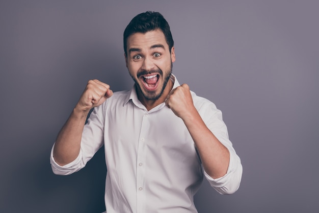 Photo of young macho business man hold fists open mouth