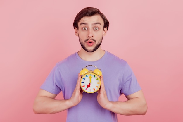 Photo of young man amazed shocked surprised late miss deadline clock timer isolated over pastel color background