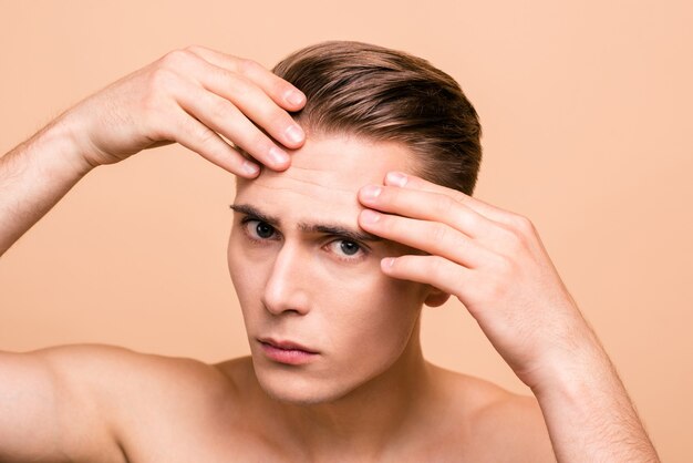 Photo of young man posing isolated on pastel beige