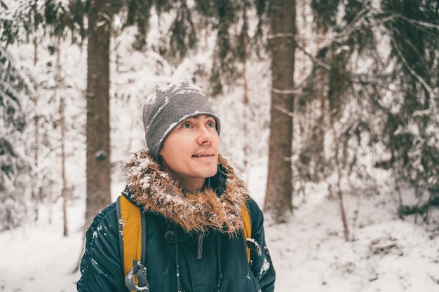冬の森を散歩する若い男の写真