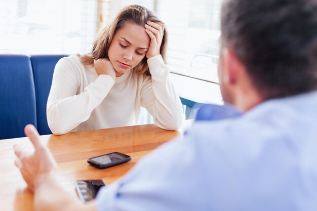 Photo of young man with sad woman in cafe