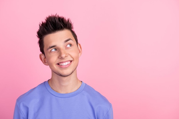 Photo of young man wonder good mood curious look empty space isolated over pastel color background