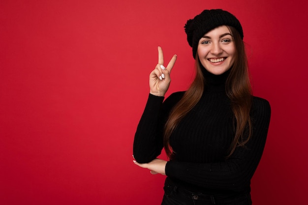 Photo of young positive happy attractive brunette woman with sincere emotions wearing black rollneck