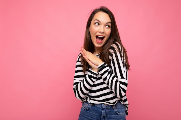 Photo of young positive happy surprised beautiful brunette woman with sincere emotions wearing casual striped pullover