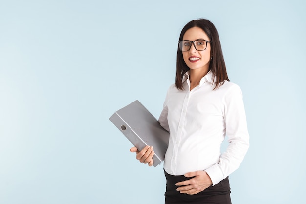 Photo of a young pregnant business woman isolated holding folder.