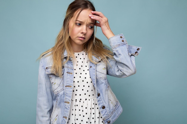 Photo of young sad upset attractive blonde woman with sincere emotions wearing jean blue jacket