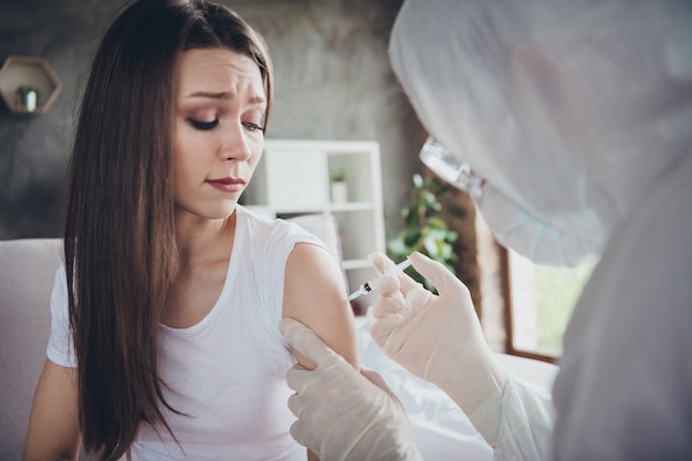 photo of young sick crying terrified patient lady injection hand shoulder