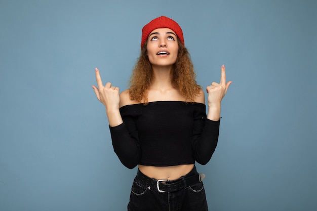 Photo of young surprised amazed attractive brunette curly woman with sincere emotions wearing black