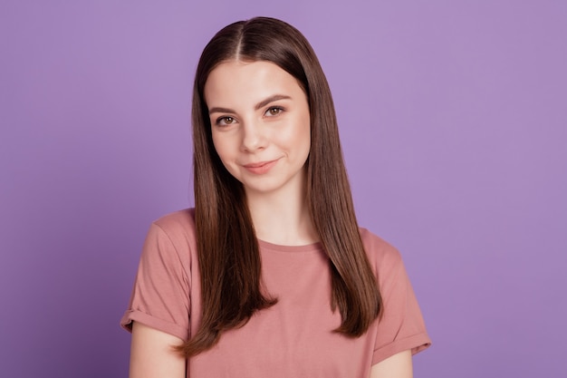 Photo of young sweet smiling girl isolated on purple background