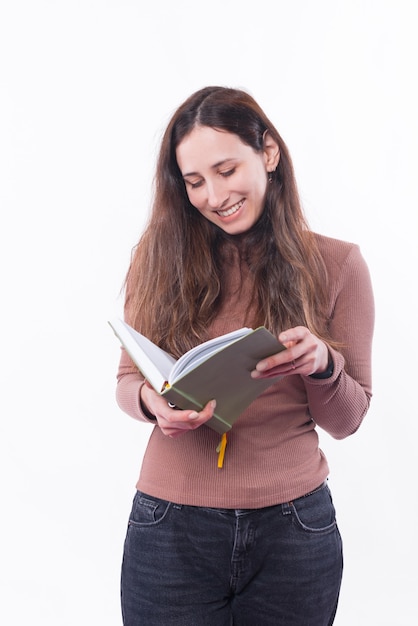 Photo of young woman checking her agenda over white wall