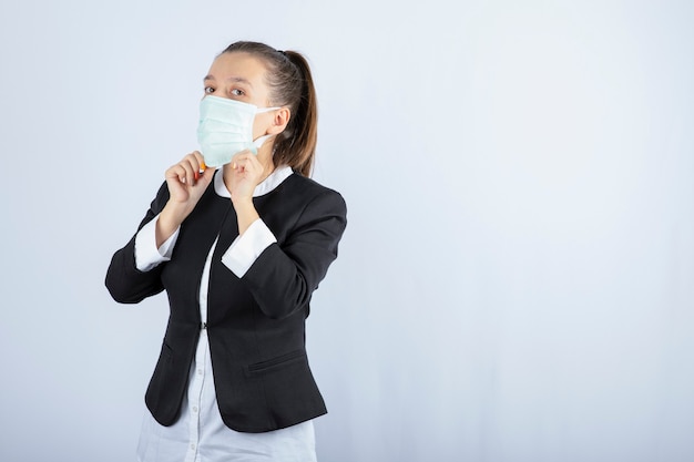 Foto di giovane donna che indossa maschera medica su sfondo bianco. foto di alta qualità