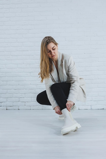 Foto di una giovane donna con stivali bianchi e abiti casual nuova collezione di scarpe invernali da donna in vera pelle