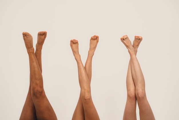 Photo photo of young women legs, multiracial friends. isolated on white background.