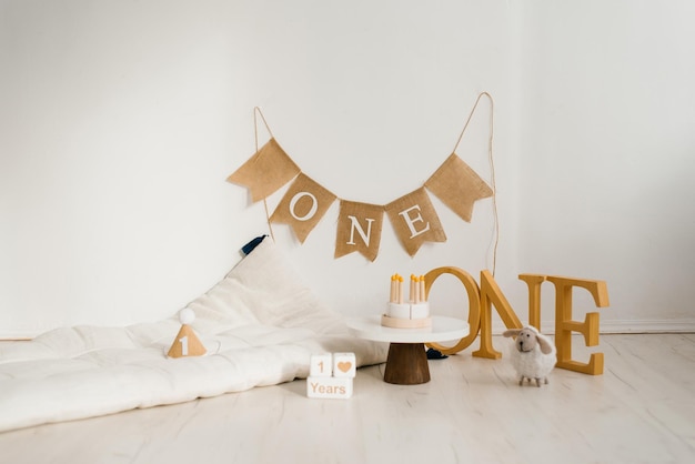 Photo zone for an anniversary or birthday with a mattress wooden toys and a birthday cake