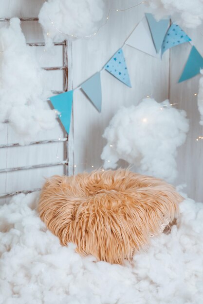 Photo zone for newborns a basket with fur in the clouds with stars stairs and flags