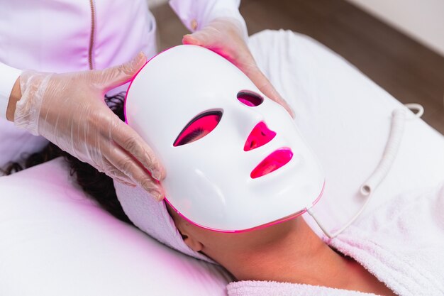 Photodynamic therapy facial mask on woman's face