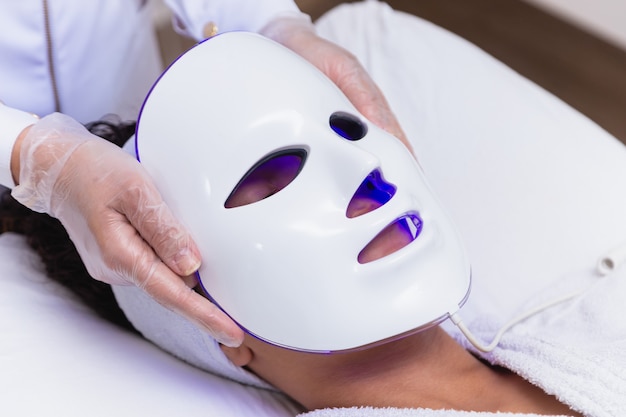 Photodynamic therapy facial mask on woman's face