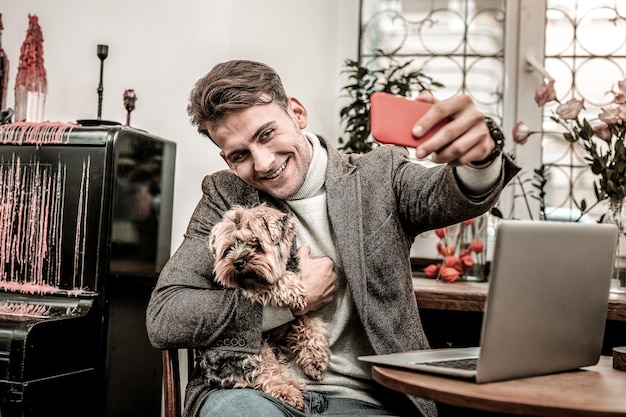 フォトジェニックな犬。犬と一緒に自分撮りをする男