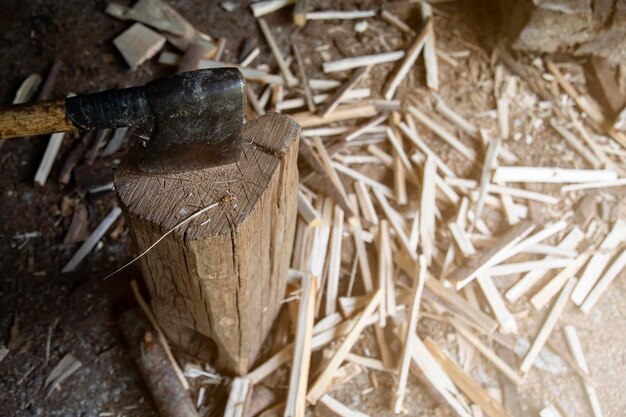 Photograph of an axe nailed to a background and cut wood on the floor to be placed in the storage room rural life copy space