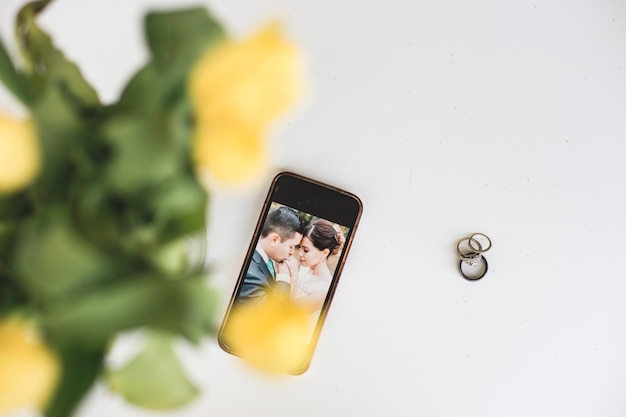 Photo photograph of bride and bridegroom on mobile phone screen