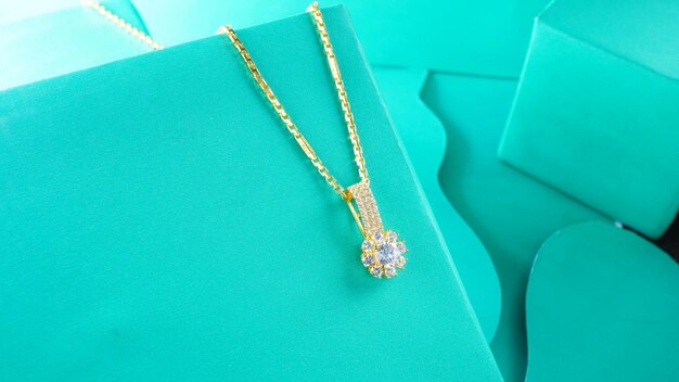 a photograph of a gold necklace on a blue background