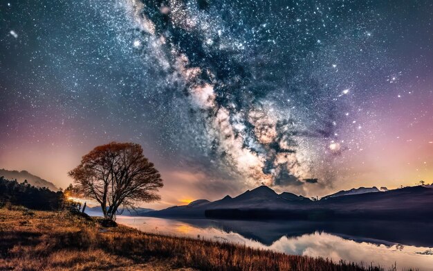 Foto foto del lago di notte con le montagne sullo sfondo e il cielo stellato