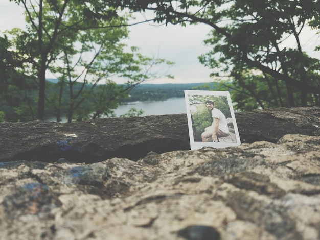 Photo photograph of man on rock