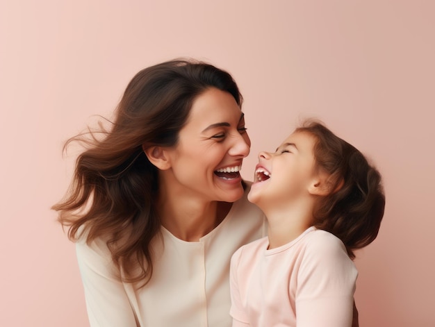 Photograph of mother with her little daughter in good mood wearing pink tshirt on pink background