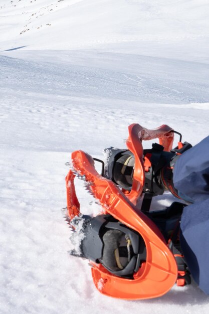 Фото Фотография снегоходов с большими лопастями, помещенными на ноги, лежащие на снежном склоне