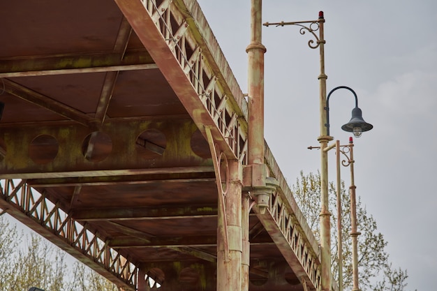 Photograph of an old and rusty bridge seen from below