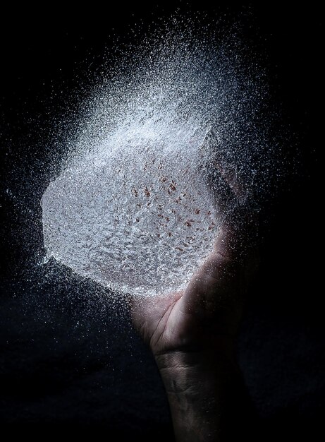 A photograph showing the water droplets formed by throwing a body of water in his hand.