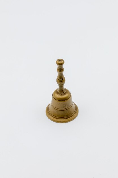 Photo photograph of a small bronze bell on white