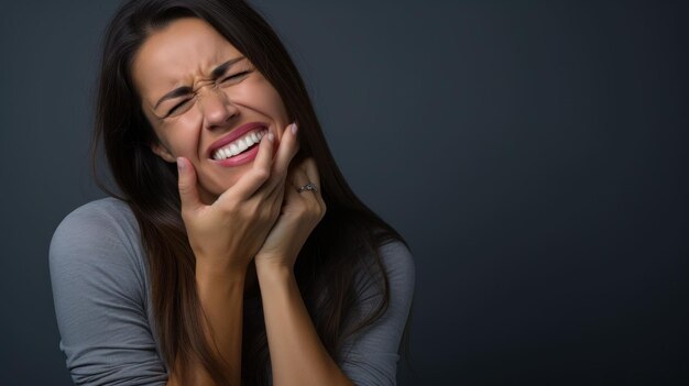 Foto fotografia di una donna nello studio che mette la mano sulla guancia a causa del dolore al dente con un'espressione dolorosa sul viso su uno sfondo semplice