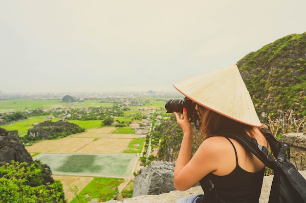 Fotografo donna asiatica con fotocamera reflex a ninh binh, vietnam