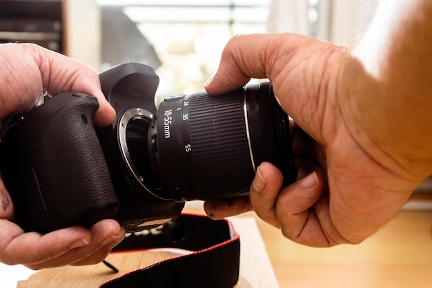 Fotografo che collega un obiettivo a una fotocamera professionale