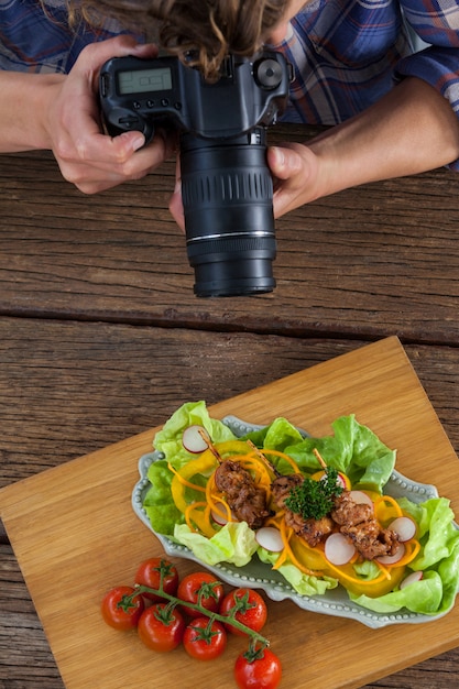 Photo photographer clicking a picture of food using digital camera