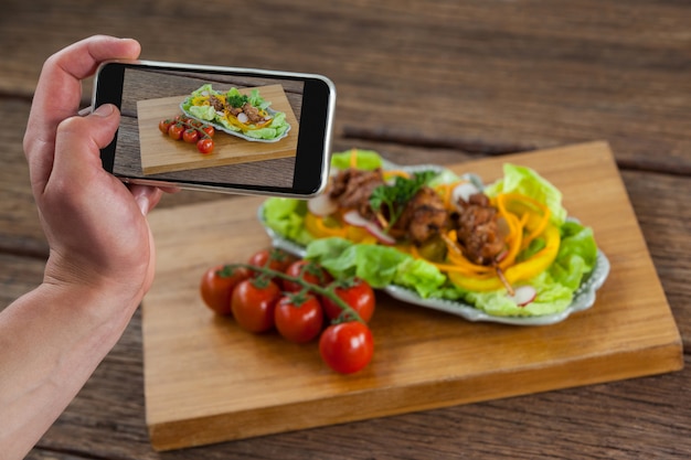 Photographer clicking a picture of food using smartphone