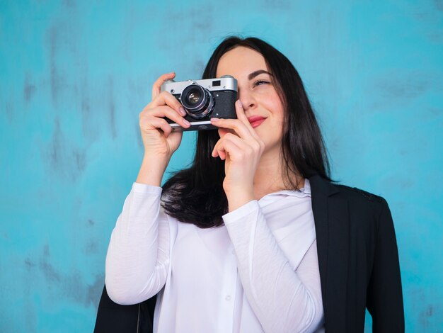 Fotografo. chiuda sulla giovane donna di colpo in testa del ritratto che prende le immagini con la retro macchina fotografica d'annata