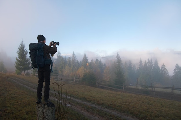 Photographer hiker taking picture of nature with digital camera