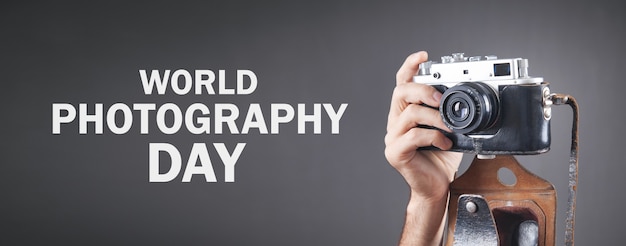 Photo photographer holding old camera. world photography day