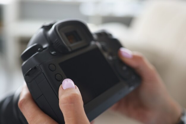 Photographer holds camera in his hands closeup