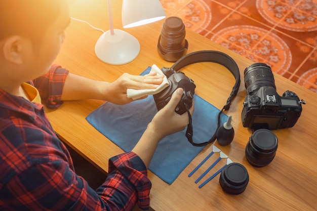 Foto il fotografo sta pulendo la sua macchina fotografica da solo.