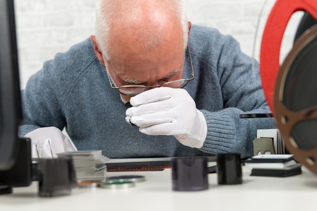 Photographer looking at negative film with a magnifying glass