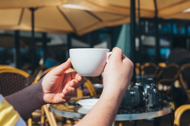 写真家の男がレストランでコーヒーを飲む