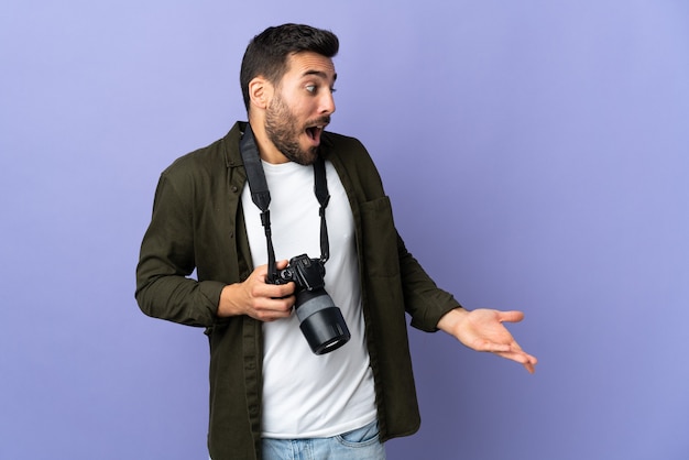 Photographer man over isolated purple background with surprise expression while looking side